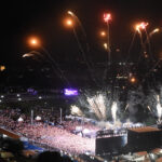 Fireworks rise above the Bell Stage and a large festival crowd