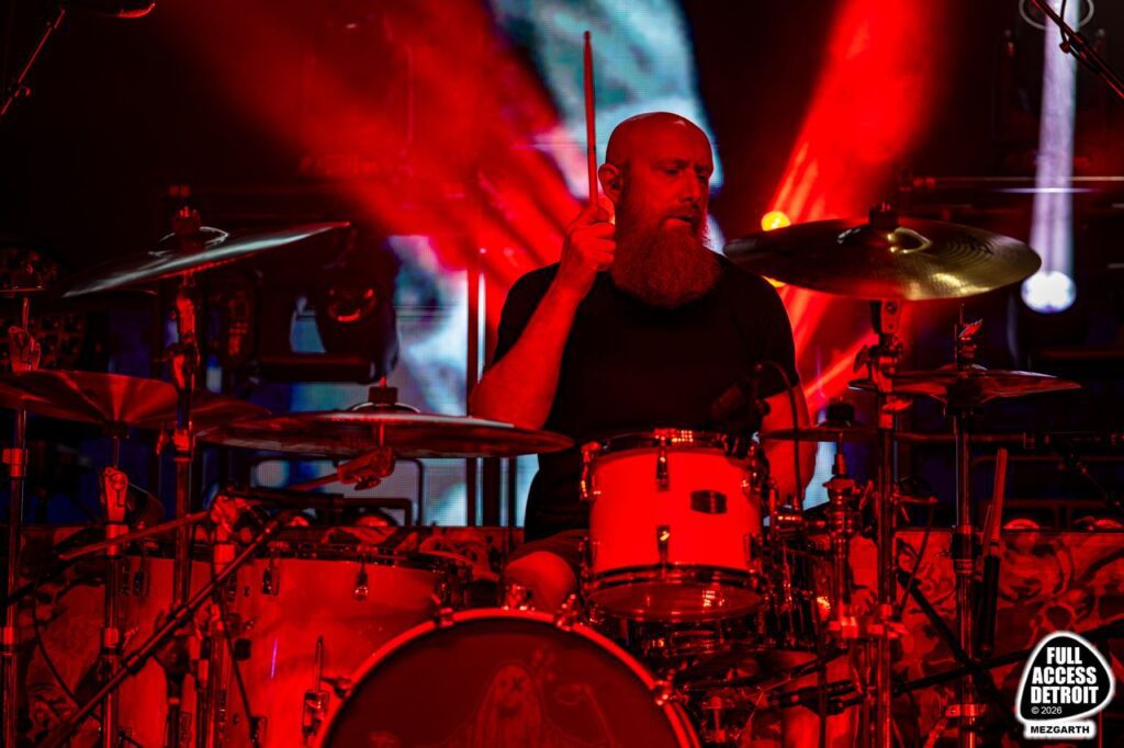 Killswitch Engage drummer performing under red stage lights