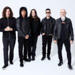 The five members of Anthrax standing together against a light background