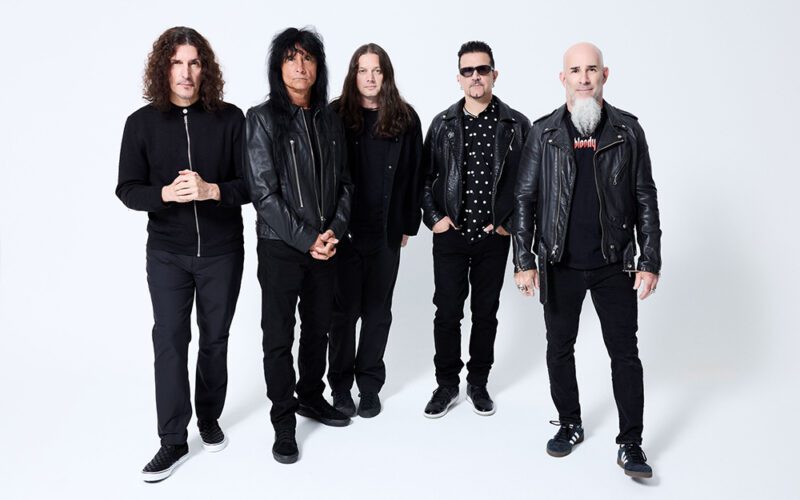 The five members of Anthrax standing together against a light background