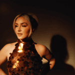 Maggie Rose in a sequined outfit against a dark background