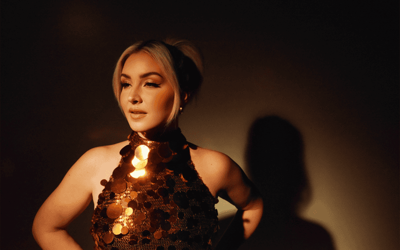 Maggie Rose in a sequined outfit against a dark background