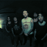 The members of Saliva posing together in a dark tunnel
