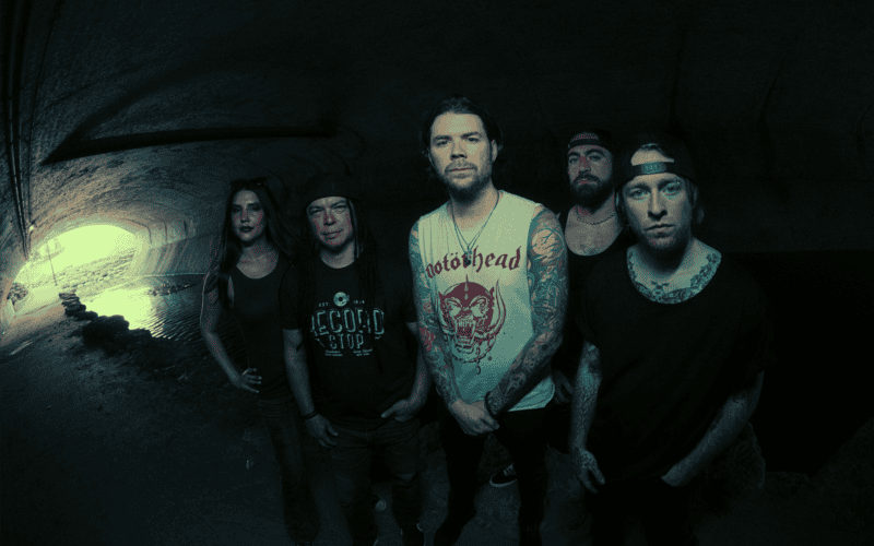 The members of Saliva posing together in a dark tunnel
