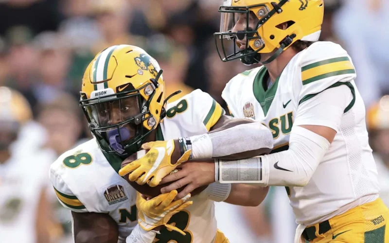 Football players in white and yellow uniforms during a play