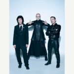 The Smashing Pumpkins posing together against a pale studio background.