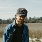 Wyatt McCubbin wearing a cap and denim jacket outdoors.